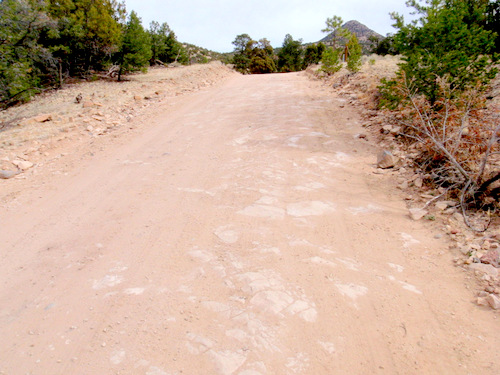 The places with more hard rock form the crests of of the road.